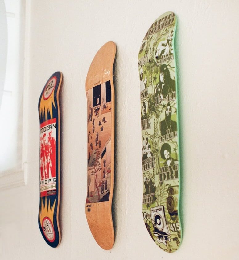 3 planches de skateboard accrochées sur un mur.